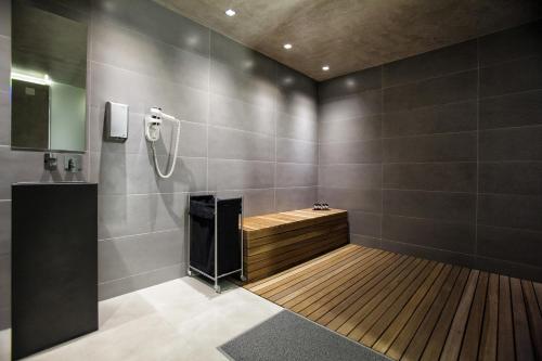 a bathroom with a shower with a wooden bench at Porto Palace Hotel Thessaloniki in Thessaloniki
