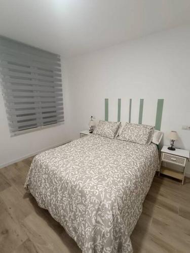 a white bedroom with a bed and a window at Encantador apartamento completo con dos habitaciones in Madrid