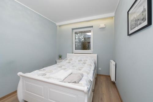 białe łóżko w pokoju z oknem w obiekcie Luxury in the City-10-KsiezyMlyn&GaleriaLodzka w Łodzi