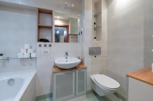 a white bathroom with a sink and a toilet at Airport&AtlasArena&OrientariumParking in Łódź