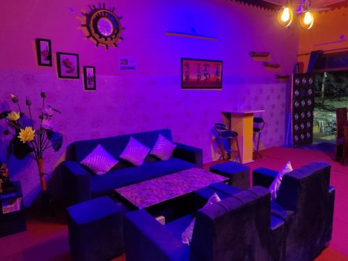ein lila Zimmer mit einem Sofa und einem Tisch in der Unterkunft Moupiya Resort and Restaurant in Dāngchura