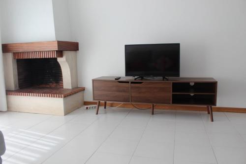 a living room with a television and a fireplace at Beach House in Vila do Conde
