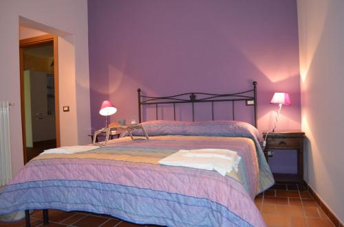 a bedroom with a bed with purple walls and two lamps at B&B La casa di Giulietta in Castelmezzano