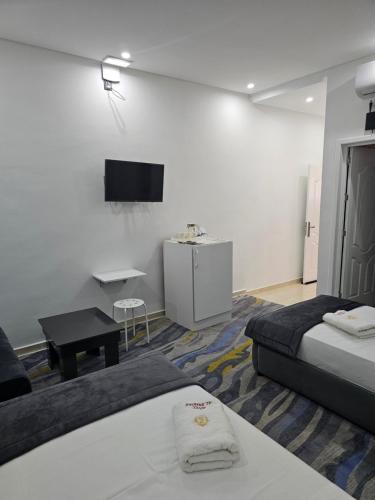 Cette chambre comprend 2 lits et une télévision à écran plat. dans l'établissement فندق الشموخ Hotel Al Shmokh, à Aousserd