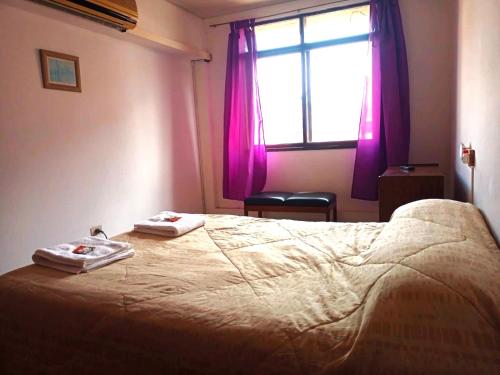 1 dormitorio con 1 cama con 2 toallas en Departamento Bombal Mendoza en Mendoza