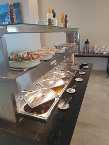 a buffet line with plates and bowls of food at LC Palace Hotel in Capim Grosso