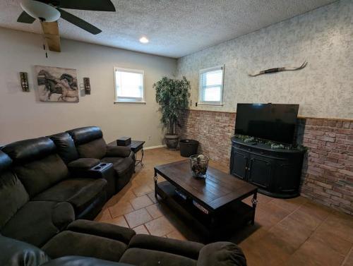 a living room with couches and a flat screen tv at Cozy Family Home in Texas in Fort Worth