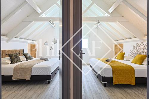 twee bedden in een kamer met witte muren en ramen bij 5 bed-rooms Front-Beach apartment at Orient Beach in Saint Martin