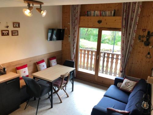 un salon avec une table et un canapé dans l'établissement Appartement lumineux avec balcon et parking, 6 pers. - FR-1-198-241, à Châtel