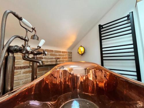 a wooden bath tub in a bathroom with a sink at Old Post Office in Sherborne