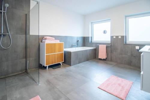 ein Badezimmer mit einer Dusche, einer Badewanne und einem Waschbecken in der Unterkunft Große Stadtvilla mit Whirlpool in Otterberg