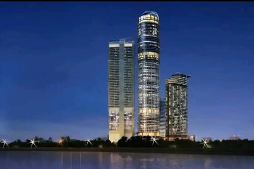una rappresentazione di un edificio alto di notte di AmigosStay - High Rise Studio with river view. a Noida