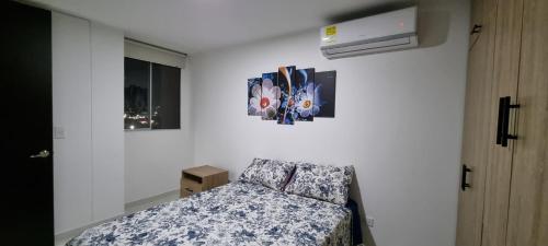 - une chambre avec un lit et une photo sur le mur dans l'établissement Excelente y cómodo apartamento, vista hermosa y seguridad privada. p7, à Cúcuta