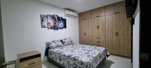 - une chambre avec un lit et une armoire en bois dans l'établissement Excelente y cómodo apartamento, vista hermosa y seguridad privada. p7, à Cúcuta