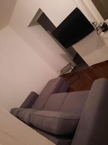 un salon avec un canapé et une télévision dans l'établissement Agréable maison de pêcheurs avec parking gratuit., à Grand-Fort-Philippe