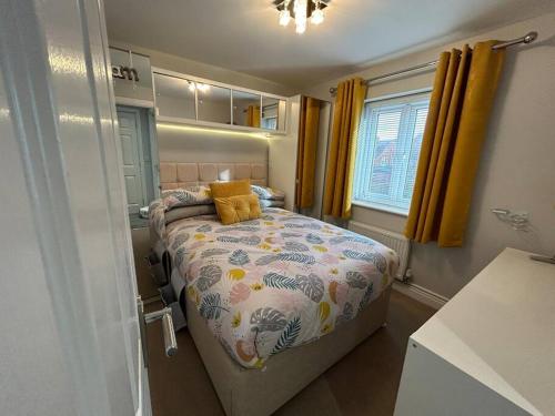 a small bedroom with a bed with yellow curtains at Spacious House To Accommodate 6 in Willaston