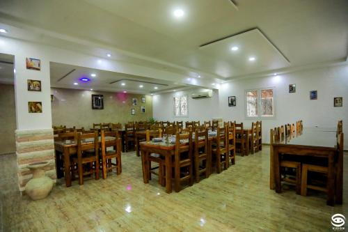 une salle à manger avec des tables et des chaises en bois dans l'établissement Dar Barka, à Kebili