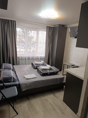 a bedroom with a bed with blue pillows on it at Apart 41 in Almaty