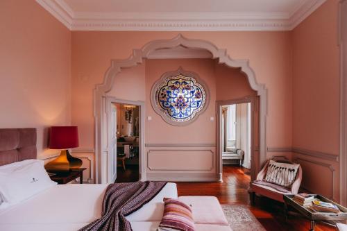 um quarto com uma cama e um lustre na parede em Torel Palace Lisbon em Lisboa
