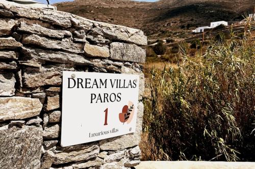 a sign on the side of a stone wall at Dream Villas Paros 1 ολόκληρος χώρος με πισίνα in Parikia