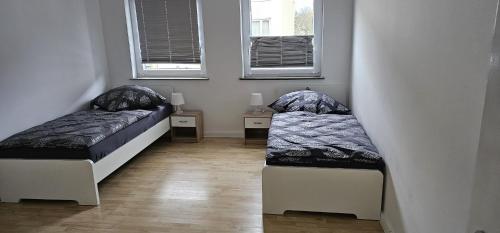 2 Betten in einem Zimmer mit 2 Fenstern in der Unterkunft SES12 1-OG rechts Monteurwohnung in Wolfsburgs Zentrum in Wolfsburg