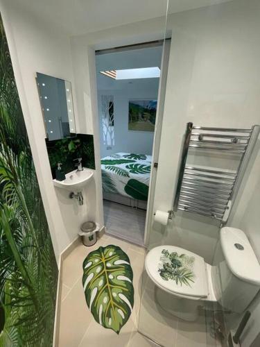 a bathroom with a toilet and a sink and a mirror at Cosy Jungle Cabin With Bathroom 