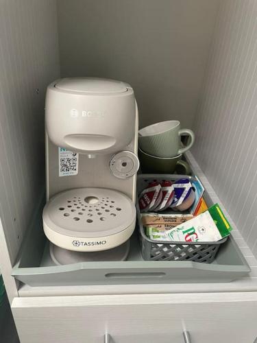 a shelf in a refrigerator with a coffee maker and other items at Cosy Jungle Cabin With Bathroom 
