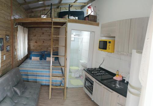 a small kitchen with a bunk bed in a tiny house at Dunas Tiny House casa 1 in Florianópolis