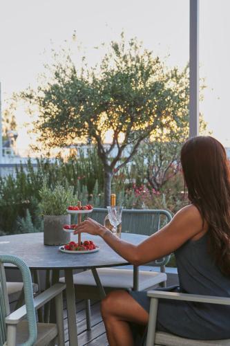 a woman sitting at a table with a plate of food at Brasil Suites Boutique Hotel in Athens