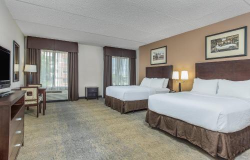 Holiday Inn Louisville Airport - Fair/Expo, an IHG Hotel في لويزفيل: غرفة فندقية بسريرين وتلفزيون بشاشة مسطحة