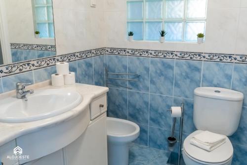 a blue and white bathroom with a toilet and a sink at Santa Beach Villa - 3 bedrooms & BBQ in Santa Cruz