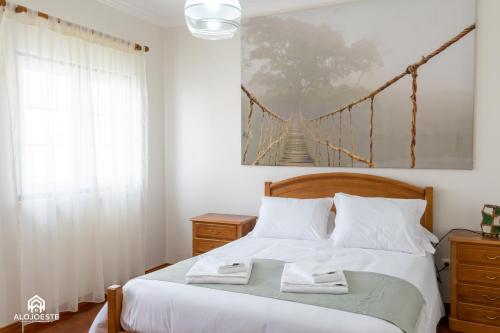 a bedroom with a bed with a bridge painting on the wall at Santa Beach Villa - 3 bedrooms & BBQ in Santa Cruz