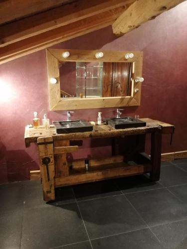 a bathroom with a wooden vanity with two sinks and a mirror at Lumieres de Courchevel in Bozel