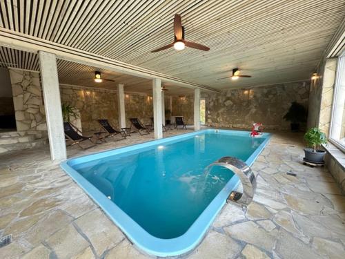 une grande piscine avec un ventilateur de plafond sur la terrasse dans l'établissement Hotel Roter Kater, à Cassel