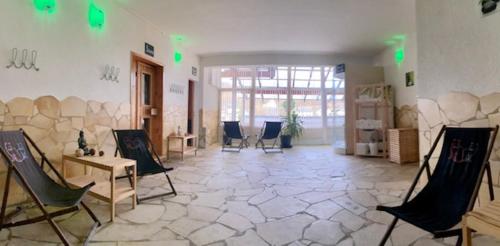 a large room with chairs and a room with a stone floor at Hotel Roter Kater in Kassel