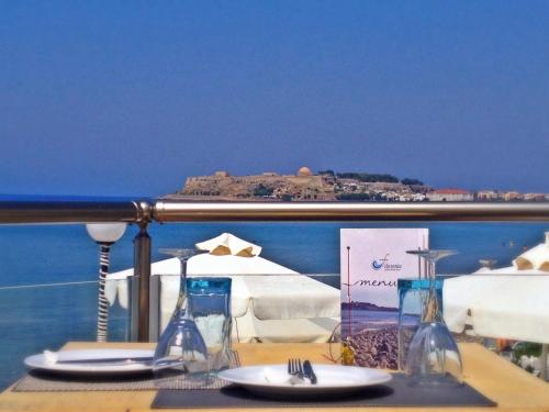 a table with a view of the ocean and an island at Filoxenia Beach Hotel in Rethymno Town