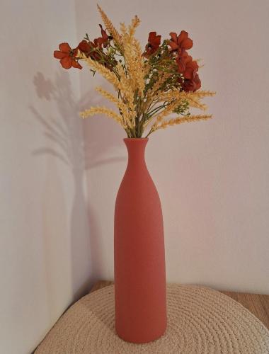 a pink vase with flowers in it on a table at Villa Le Cyprès classée 4 Etoiles billard, piscine et jacuzzi in Saint-Joseph