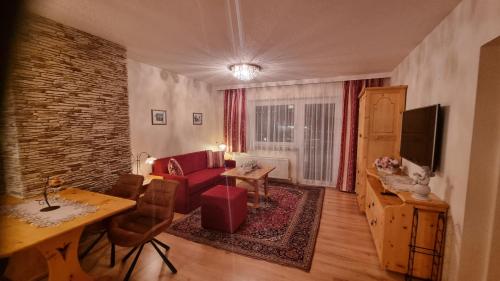 un soggiorno con divano rosso e tavolo di Appartement Michelle a Juns