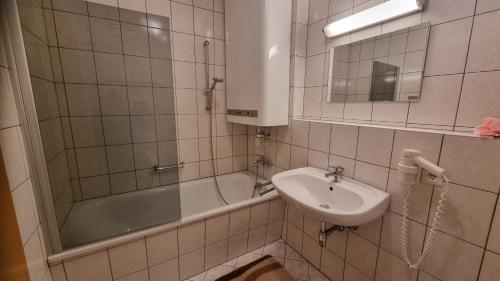 bagno con lavandino, vasca e lavandino di Appartement Michelle a Juns