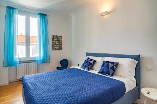 una camera con letto blu e tende blu di [Navigli-Centro] Comfort suite con WiFi a Milano