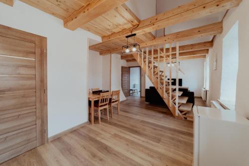 um quarto com uma escada de madeira e uma sala de jantar em Ubytovanie Starý dvor em Spisské Podhradie