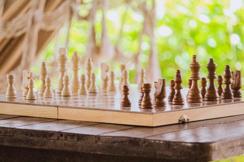 a wooden chess set on a wooden table at No Worries Pipa in Pipa
