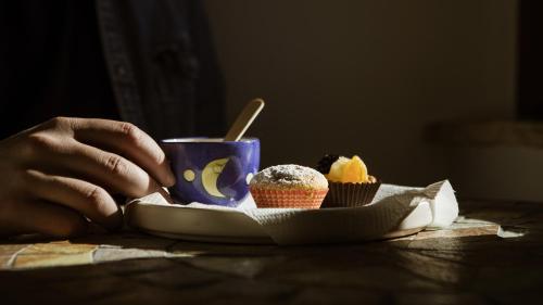 a person sitting at a table with a plate of cupcakes at Tenute Donna Franca in Elice