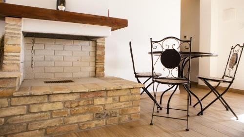 a brick fireplace with two chairs and a table at Tenute Donna Franca in Elice