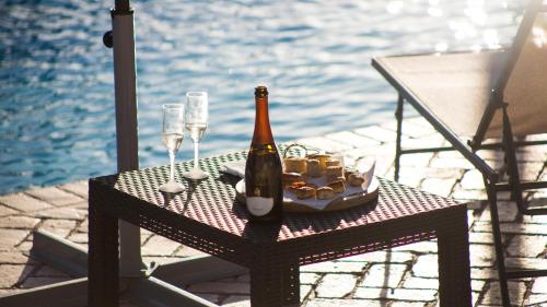 a bottle of champagne and glasses on a table next to the water at Tenute Donna Franca in Elice