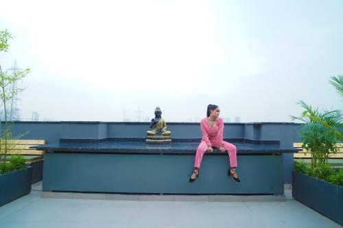 a woman is sitting on a blue bench at Saltstayz Select - Golf Course Road & Sector 57 in Gurgaon