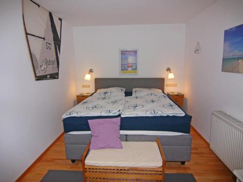 a small bedroom with a bed and a chair at Apartment Raum in Fehmarn Orth in Orth