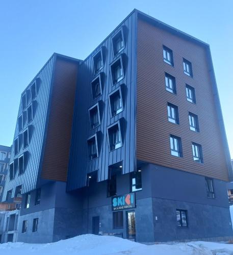 a large building with snow in front of it at SKYLUX apartments 7 in Jahorina