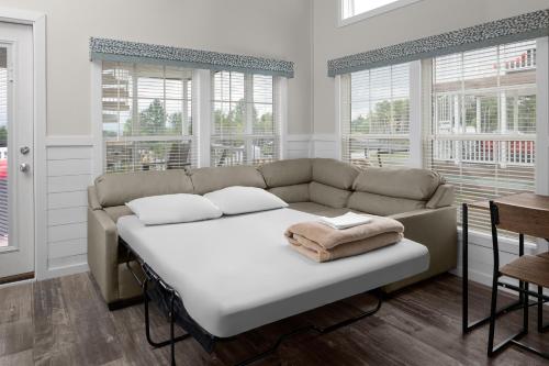 a living room with a couch and windows at Jellystone Park TM Petoskey in Petoskey