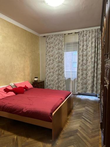 a bedroom with a red bed and a window at Da Tiziana in Turin